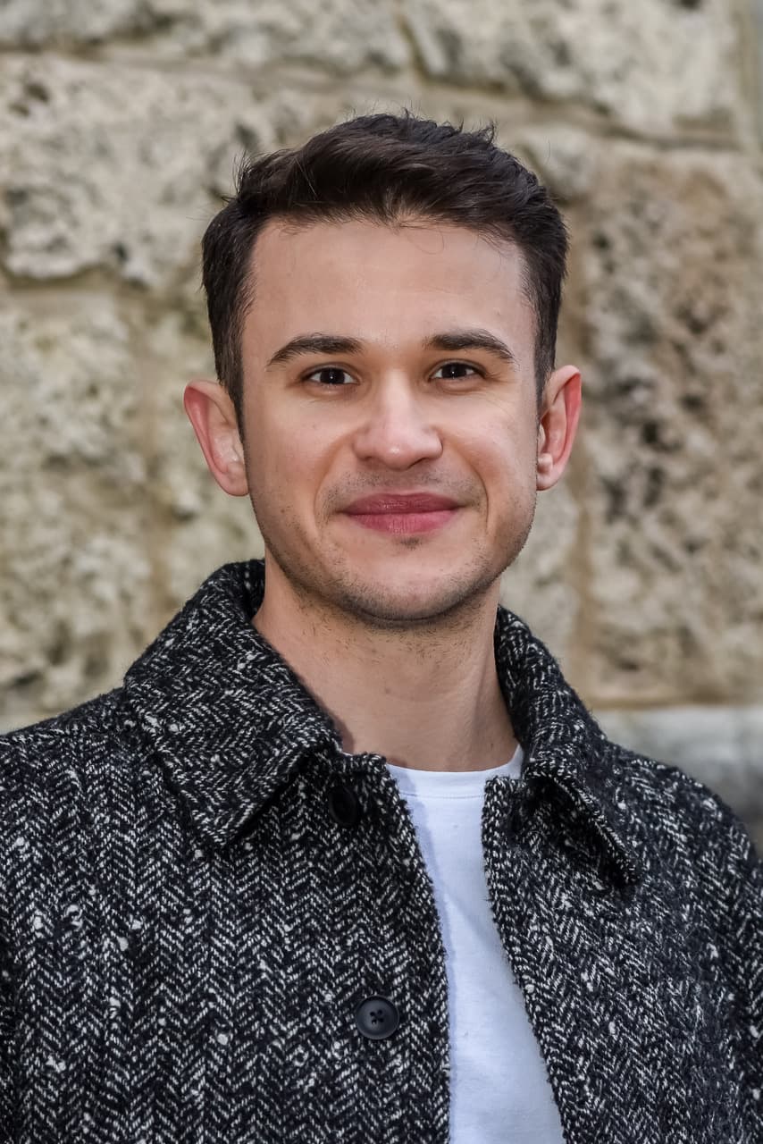 Porträt von Koray Kaya vor einer hellen Natursteinmauer